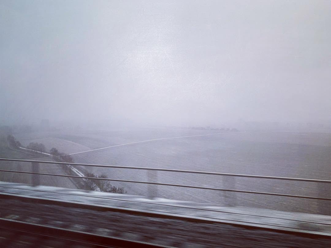 Snowy field seen from a moving train.
